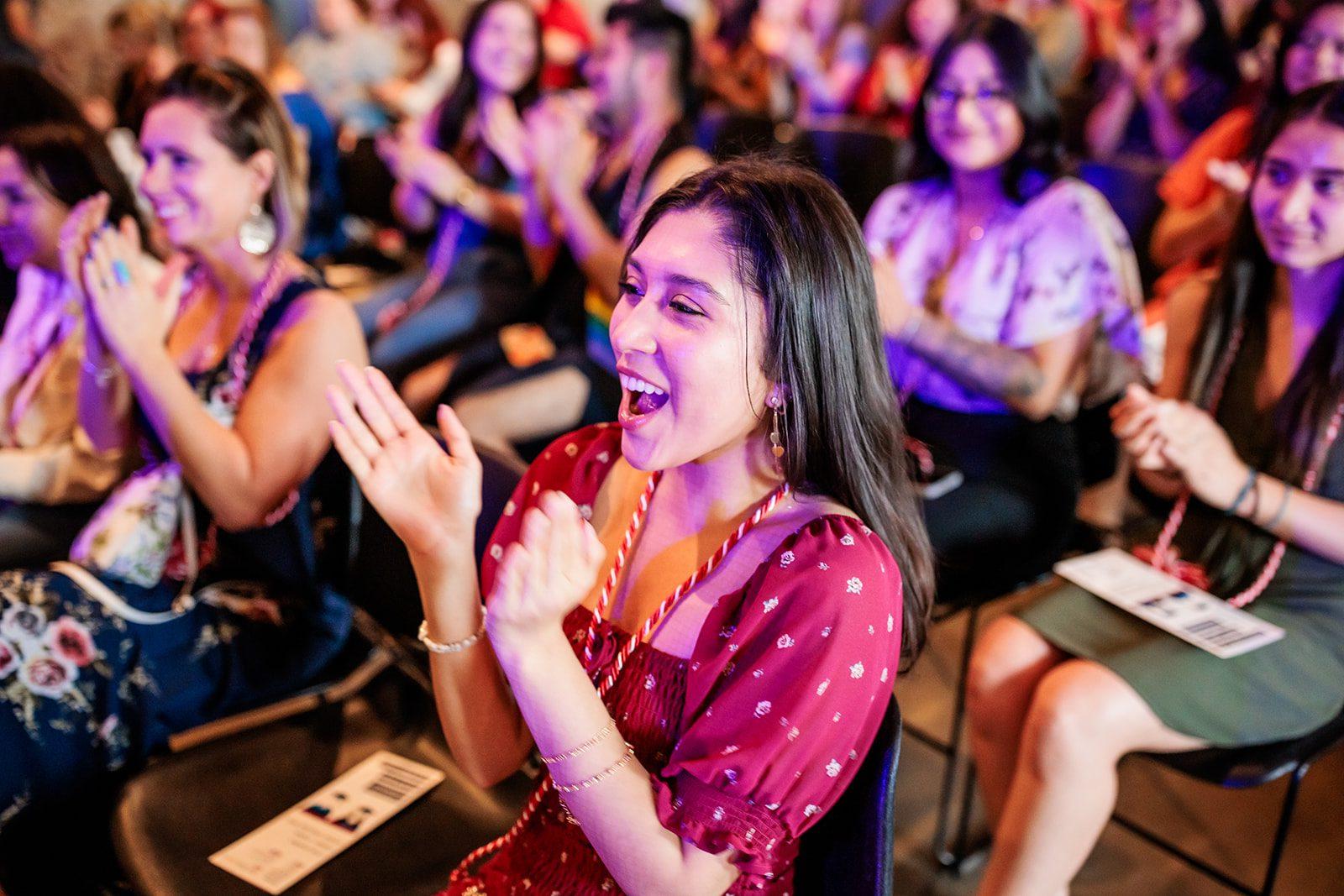 Image of graduate clapping at ceremony.